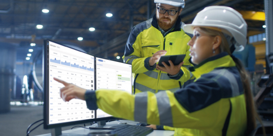 Woman in PPI pointing to a computer screen